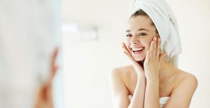 Ung kvinna, hudvårdsrutin, tvättar ansiktet